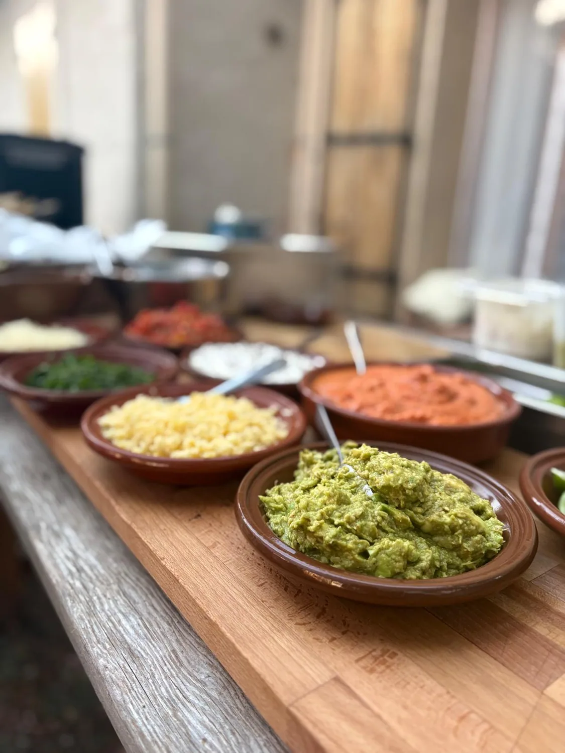 Guacamole et sauces colorées dans des bols en terre cuite.