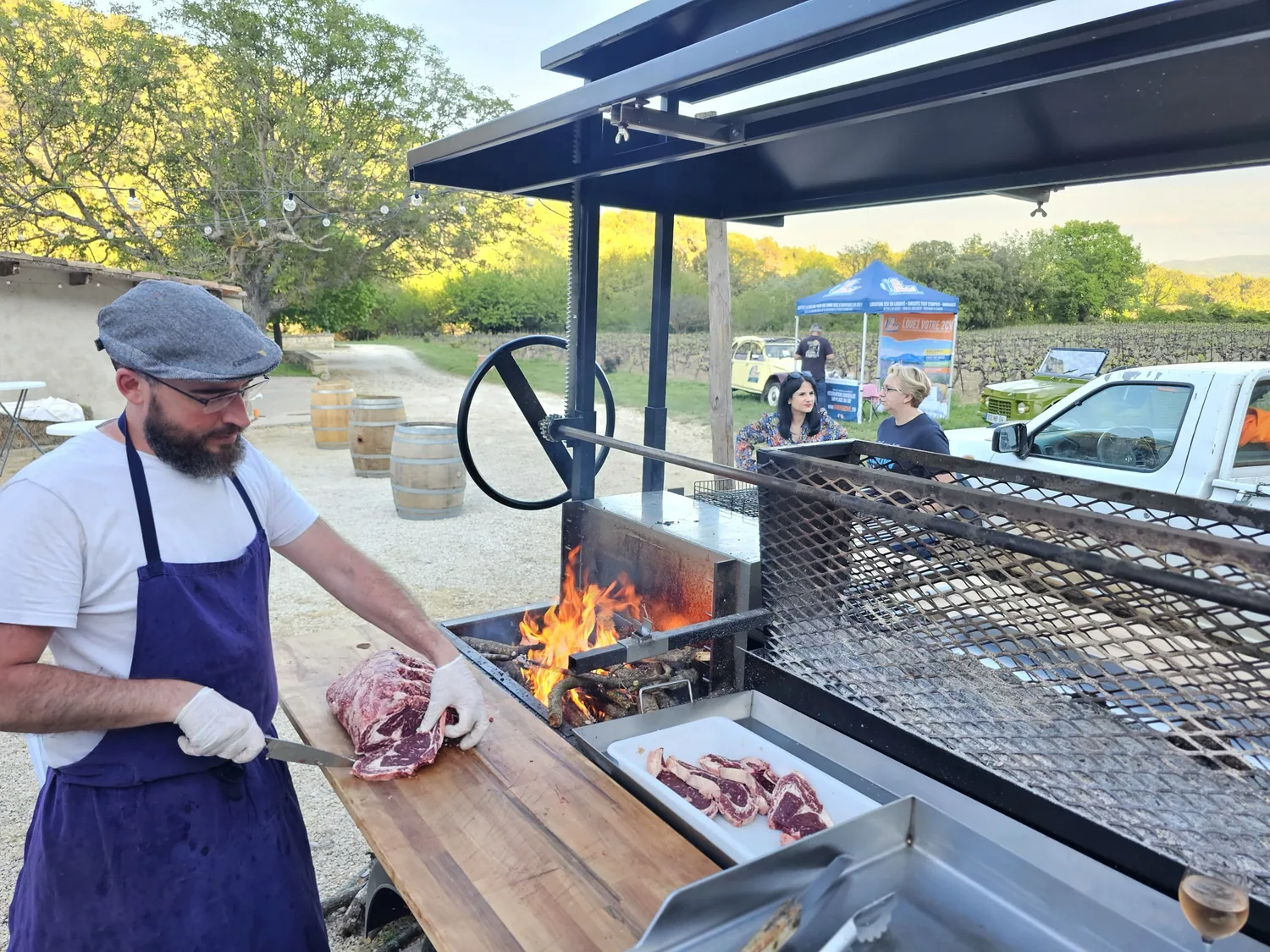 Le cuisinier découpe une pièce de bœuf près du feu