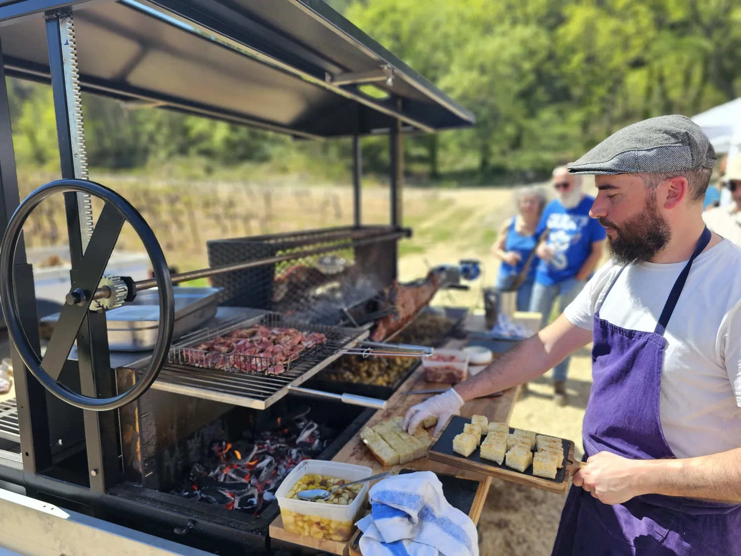 Préparation de bouchées devant le feu et la rôtisserie.