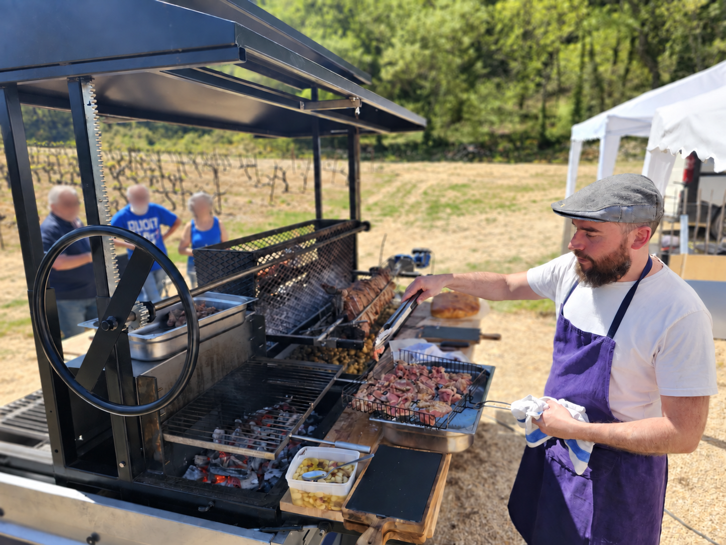 Le chef du Gramboisien surveille la cuisson au tournebroche dans un vignoble